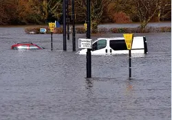  ??  ?? Vehicles are left stranded in this flooded Shrewsbury car park