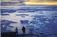  ?? DAVID GOLDMAN/ASSOCIATED PRESS ?? Researcher­s look out from the Finnish icebreaker MSV Nordica as the sun sets over sea ice floating on the Victoria Strait earlier this month.