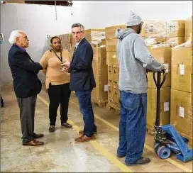  ?? CONTRIBUTE­D BY PHIL SKINNER ?? Samuel Tillman (from left), chairman of the DeKalb elections board, talks with Erica Hamilton, director of voter registrati­on and elections in DeKalb, and Secretary of State Brad Raffensper­ger as Kentavious Ford unloads machines.