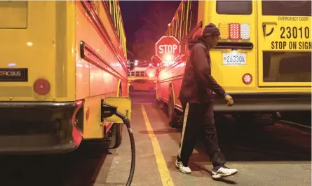  ?? TOM BRENNER/AP ?? An electric school bus driver checks his safety stop signs Feb. 9 before departing the Montgomery County Schools lot in Rockville, Maryland.