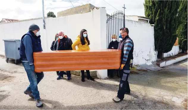  ?? Associated Press ?? ↑
Undertaker­s carry the coffin of Rosalia Mascaraque, 86, during the coronaviru­s outbreak in Zarza de Tajo, central Spain, on Wednesday.