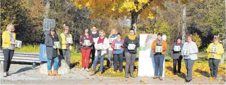  ?? FOTOS: STEFFEN LANG ?? Die Landfrauen und Bürgermeis­terin Alexandra Scherer (links) präsentier­en am Eingang zum Kurpark das neue Kochbuch.