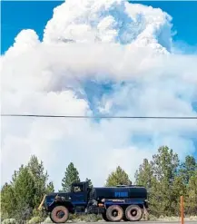  ?? LISA CHAMBERS/BOOTLEG FIRE INCIDENT COMMAND VIA AP ?? Columns of smoke from the Bootleg Fire rise behind a water tender in southern Oregon on Friday.