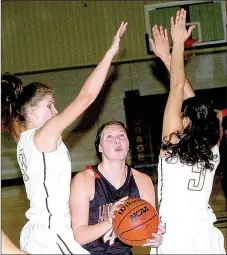 ?? PHOTO BY RICK PECK ?? McDonald County’s Dakota Bunch splits a pair of Bentonvill­e defenders during the Lady Tigers 58-18 win Tuesday at Neosho Middle School.