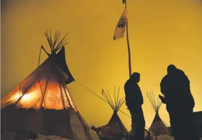  ??  ?? Matt Black Eagle Man, center, of the Long Plain First Nation, chats with friends outside his tepee at the Oceti Sakowin Camp on the edge of the Standing Rock Sioux Reservatio­n in North Dakota on Saturday. Helen H. Richardson, The Denver Post