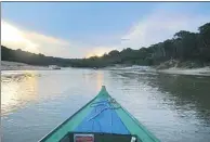  ?? PETER PRENGAMAN / AP ?? Left: A sunset in the Amazon rain forest is seen from a tributary of the Rio Negro outside Manaus, Brazil. Right: Young tourists look on as a man feeds fish to pink dolphins in the Rio Negro.