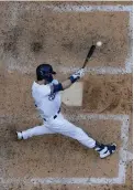  ?? AP Photo/Morry Gash ?? ■ Milwaukee Brewers’ Christian Yelich hits a single during the seventh inning against the Cincinnati Reds on Wednesday in Milwaukee.