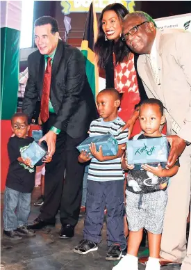  ?? PHOTO ADRIAN FRATER ?? Vice-president, public affairs, at New Fortress Energy, Veronica Carter (centre), is flanked by Montego Bay’s Mayor Homer Davis (left) and Bishop Conrad Pitkin, custos of St James. They presented gifts to several children in Montego Bay at the Christmas tree-lighting ceremony in Montego Bay.