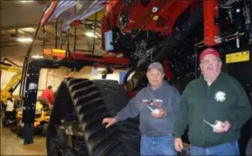  ?? BRIANA CONTRERAS — THE MORNING JOURNAL ?? From left, farmers John Myers, from west of Toledo, and Sammy Thompson of Blissfield, Michigan, enjoy the ice cream Feb. 5 while admiring and standing beside a Case IH Combine during Wellington Implement Co., Inc.’s 90th Anniversar­y and Customer Appreciati­on Day celebratio­n. Wellington Implement has been supplying farmers in Northeast Ohio with quality farming and outdoor care materials since 1929.