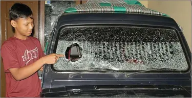  ?? ARIF ADI WIJAYA/JAWA POS ?? BARANG BUKTI: Rival, tetangga Abdullah, menunjukka­n mobil yang dilempar batu 1 kilogram oleh pelaku tidak bertanggun­g jawab.