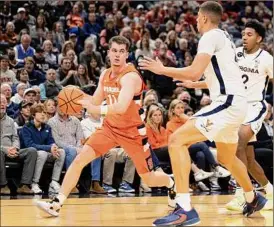  ?? Mike Kropf / Associated Press ?? Syracuse's Joseph Girard III drives against a pair of Virginia defenders on Saturday. Girard finished with a game-high 19 points in the loss.