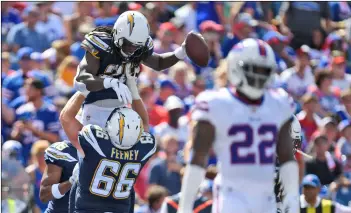  ?? AP PhOTO/ADRIAn KRAuS ?? Los Angeles Chargers’ melvin Gordon (top left)celebrates a touchdown with Dan Feeney during the first half of an NFL football game against the Buffalo Bills, on Sunday in Orchard Park, N.Y.