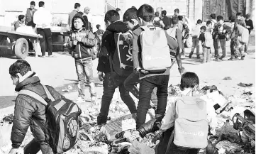  ??  ?? Iraqi children walk to school in the battered city of Mosul on Dec 27, 2017.