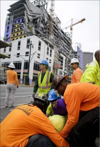  ?? SCOTT THRELKELD — THE ASSOCIATED PRESS ?? A worker is treated after a large portion of a Hard Rock Hotel under constructi­on suddenly collapsed in New Orleans on Saturday. . It has been under constructi­on for the past few months.