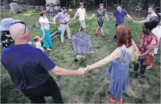  ?? CHARLES KRUPA/THE ASSOCIATED PRESS ?? Family members of Walter Skold, founder of the Dead Poets Society of America, dance around his grave.