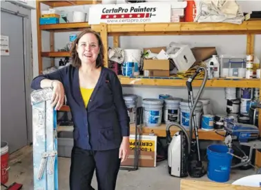  ?? AP PHOTO/CHARLES KRUPA ?? Paige NeJame, who along with her husband owns a CertaPro painting franchise, poses in a work room at her company headquarte­rs in Rockland, Mass.