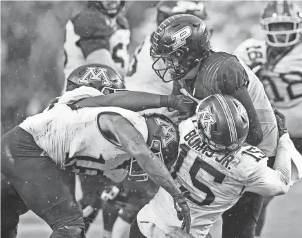  ?? MARC LEBRYK / USA TODAY SPORTS ?? Purdue quarterbac­k Aidan O'Connell is sacked by several Minnesota players earlier this month. The Boilermake­rs have allowed 15 sacks this season, third-most in the Big Ten.