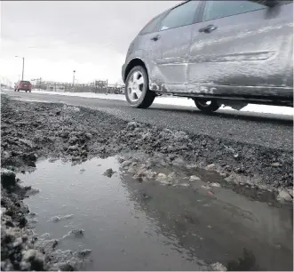  ?? CARLOS OSORIO/ THE ASSOCIATED PRESS ?? Driving into puddles and potholes can do costly damage to your car. Slow down, keep your eye on surroundin­g traffic and avoid potholes altogether if you can.