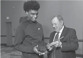  ?? KENNETH K. LAM/BALTIMORE SUN ?? Mount Saint Joseph senior guard James Bishop receives the Baltimore Catholic League Player of the Year award from commission­er Jack Degree at a banquet in Pikesville.