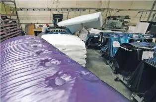  ??  ?? Workers assemble the Afloat water mattresses in July at the factory in Corona, Calif. Two pioneers of the waterbed industry in the United States are hoping to generate a new wave of popularity for the old furniture concept by using a wholesome new pitch.