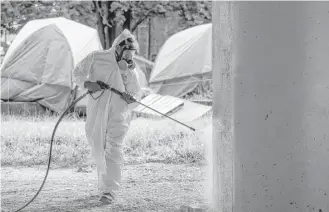  ?? Godofredo A. Vasquez / Houston Chronicle ?? City contractor­s power-wash the pillars under U.S. 59, which serve as bathrooms for many in the camp. Workers had to dig up the dirt — seen as a public health risk — around them and discard it.