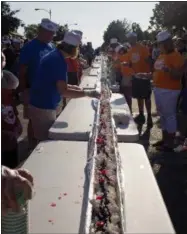  ?? ERIN LEFÈVRE — MUSKEGON CHRONICLE — ASSOCIATED PRESS, FILE ?? In this June 11, 2016file photo, an ice cream sundae is completed during the world record attempt for the longest ice cream dessert along eight city blocks in Ludington, Mich.