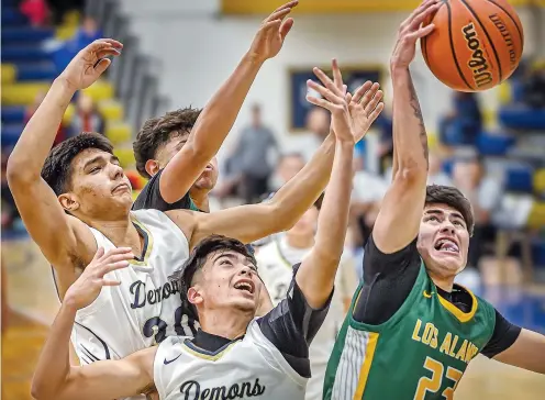  ?? JIM WEBER/NEW MEXICAN FILE PHOTO ?? Santa Fe High’s Christian Herrera, left, and Joshua Gallegos battle for a rebound with Los Alamos’ Josiah Fresquez on Dec. 1 in the Bobby Rodriguez Capital City Tournament in Santa Fe. Every weekend since the start of December, there have been at least a half dozen prep basketball tournament­s statewide, with that number increasing every year. “I mean, I look at the month of December, and I call it, ‘The Month of Tournament­s,’ ” West Las Vegas AD Richard Tripp said.