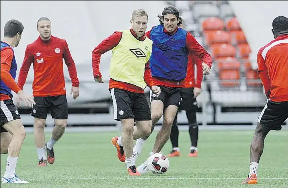  ?? MARK VAN MANEN/PNG ?? Team Canada has some fun during drills at B.C. Place Stadium on Tuesday, as they prepare for their upcoming game with Mexico. Scott Arfield, wearing the yellow bib, takes control of the ball.
