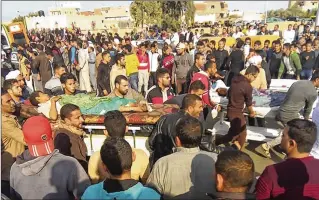  ?? ASSOCIATED PRESS ?? Rescuers evacuate injured people after at least a dozen Islamic extremists assaulted a crowded mosque with gunfire and rocket-propelled grenades during prayers Friday in Bir al-Abd, Egypt.