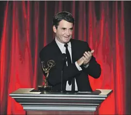  ?? Vince Bucci Invision ?? MEDICAL REPORTER Dr. Bruce M. Hensel of NBC4 accepts the award for outstandin­g news feature reporting at the L.A.-area Emmy awards in July 2014.