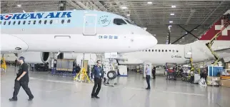  ?? RYAN REMIORZ/THE CANADIAN PRESS FILES ?? Bombardier staff work on C Series CS300 jets at the company’s plant in Mirabel, Que. The Montreal-based firm accused the U.S. of “hypocrisy” for similarly selling aircraft below production costs, as it decided to add an 80-per-cent anti-dumping duty...
