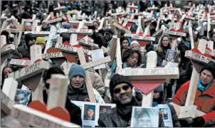  ?? ABEL URIBE/CHICAGO TRIBUNE ?? Family members, friends, and volunteers help carry over 700 crosses made by Greg Zanis along Michigan Avenue in Chicago in 2016. The crosses honored those killed that year in Chicago.