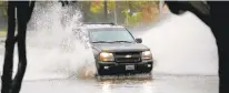  ?? JONATHON GRUENKE/STAFF ?? A vehicle drives through a flooded street in Hampton on Nov. 12.