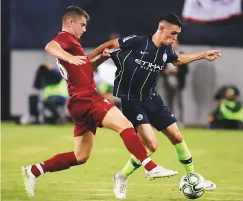  ?? AP ?? Manchester City midfielder Phil Foden (right) tries to break free in a tussle with Liverpool forward Ben Woodburn during the second half of their Internatio­nal Champions Cup match.