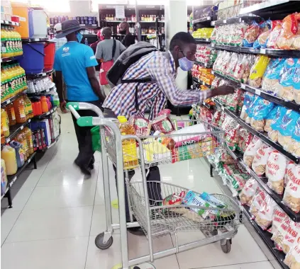  ??  ?? Supermarke­ts and other retailers that supply essential goods and services yesterday enjoyed brisk business as shoppers went ona spree to stock up ahead of the 30-day national lockdown that commences today. - Picture: Edward Zvemisha