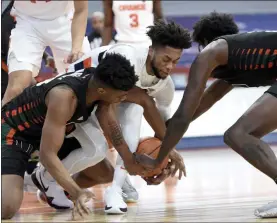  ?? DENNIS NETT ?? Miami guard Earl Timberlake, left, Syracuse forward Alan Griffin (0) and Miami center Nysier Brooks (3) scramble for a loose ball during an NCAA college basketball game Tuesday, Jan. 19, 2021 in Syracuse, N.Y.