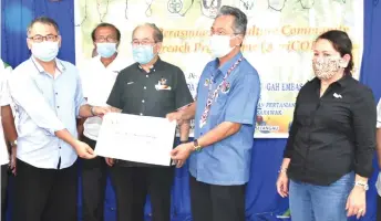  ??  ?? Uggah (centre) witnesses Nuing (second right) presenting his minor rural project grant to a recipient.