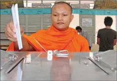  ?? HONG MENEA ?? A monk places his vote at Sisowath High School’s ballot station in Phnom Penh during the 2013 national election.