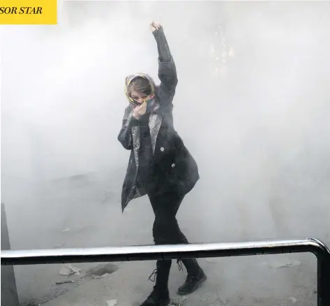  ?? THE ASSOCIATED PRESS ?? An Iranian woman raises her fist amid the smoke of tear gas at the University of Tehran in the country’s capital during a protest on Saturday.