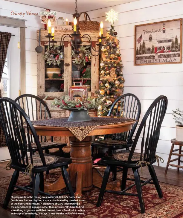  ??  ?? Shiplap walls in the dining area in Gary K. Ball Jr.’s home lend farmhouse flair and lighten a space dominated by the dark tones of the floor and furniture. A signature of Gary’s decorating is the abundance of signage rather than artwork. “It’s hard to find something to go on a wall that doesn’t have a floral print on it or an image of somebody,” he says. “I just like the look of old wood.”