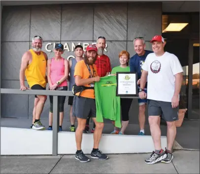  ?? The Sentinel-Record/Mara Kuhn ?? SPA PACERS: Rob Pope, front, left, with members of the Spa Pacers after they presented him with a Spa Running Festival T-shirt and medal and Descendant of DeSoto certificat­e at The Greater Hot Springs Chamber of Commerce building on Wednesday.