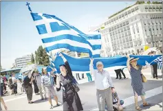  ??  ?? A woman holds a Greek flag as she takes part in a demonstrat­ion in Athens against the agreement reached to resolve a 27-year name row with Macedonia.