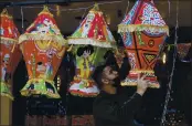  ?? MAJDI MOHAMMED — AP PHOTO ?? A Palestinia­n shopkeeper hangs Ramadan lanterns ahead of the Muslim fasting month of Ramadan, in the West Bank city of Nablus.