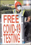  ?? DAVID J. PHILLIP/AP ?? A health care worker advertises free COVID-19 testing last week at Minute Maid Park in Houston.