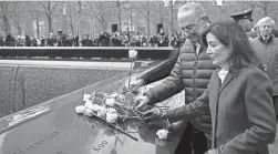  ?? JOHN MINCHILLO/AP ?? Senate Majority Leader Chuck Schumer and New York Gov. Kathy Hochul place flowers over the names of the victims of the 1993 World Trade Center bombing during a ceremony at the 9/11 Memorial in New York, Sunday.