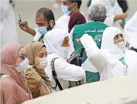  ?? Reuters ?? Hajj pilgrims, wearing protective masks because of the pandemic, cast pebbles during the symbolic stoning of the devil ritual in Mina on Tuesday.