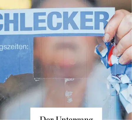  ?? FOTO: JULIAN STRATENSCH­ULTE/DPA ?? Eine Mitarbeite­rin der Drogeriema­rktkette Schlecker reißt das Firmenlogo von der Eingangstü­r einer Filiale. 25 000 Beschäftig­te verloren bei der Schlecker-pleite in ihren Job.