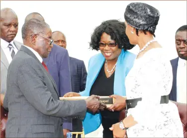  ??  ?? President Mugabe and First Lady Dr Grace Mugabe receive a laptop from Bankers Associatio­n of Zimbabwe president Dr Charity Jinya after a meeting with Business at State House in Harare yesterday. — (Picture by John Manzongo)