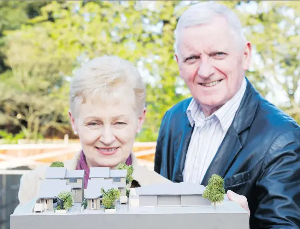  ?? PHOTOS: GERRY KAHRMANN ?? John and Kathleen Higgins hold a model that shows the family’s four new homes on the left and the original rancher on the Delta property on the right.