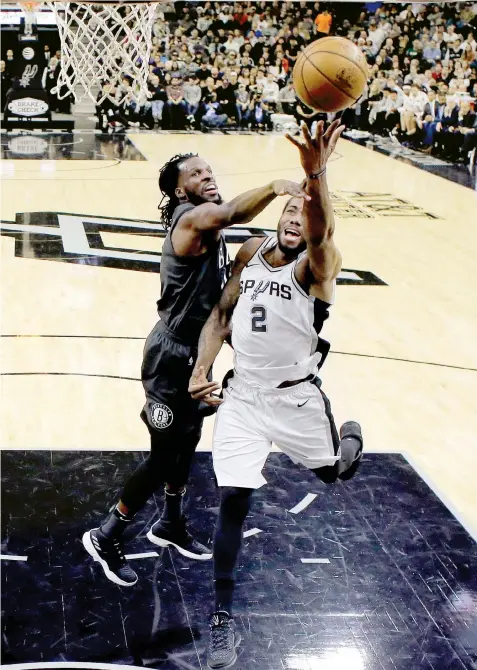  ??  ?? San Antonio Spurs forward Kawhi Leonard (2) is fouled by Brooklyn Nets center Tyler Zeller (44) as he drives to the basket during the second half of an NBA basketball game in San Antonio. San Antonio won 109-97.